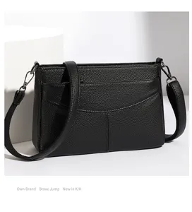 Black genuine leather shoulder bag detail view, classic crossbody style with front pocket.