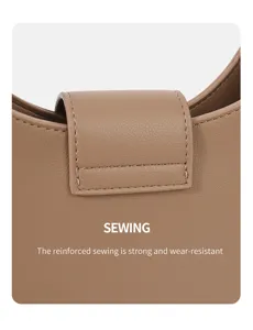 Detail view of stylish brown minimalist crescent underarm shoulder bag with reinforced sewing.