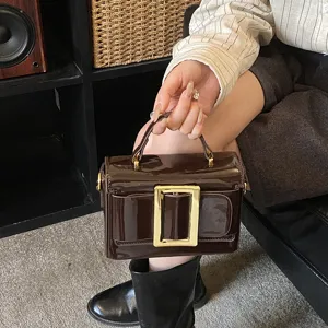 Retro patent leather handbag with a chic gold buckle, stylish small shoulder bag for women.