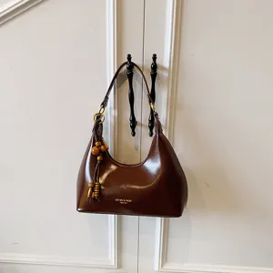 Vintage brown women underarm shoulder bag with wooden bead charm and elegant design.