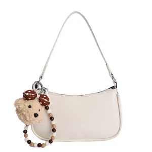 Minimalist off-white PU leather underarm shoulder bag with cute bear plush pendant.