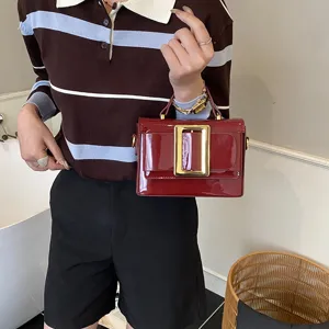 Retro patent leather shoulder bag with chic gold buckle, stylish commuting handbag for women.