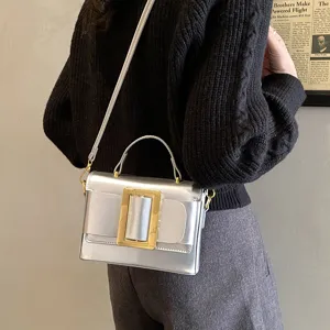 Trendy silver shoulder bag with bold gold buckle, stylish retro crossbody bag for women.
