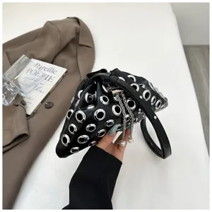 Black leather bucket bag featuring metallic grommets and pearl tassel charms for stylish women.