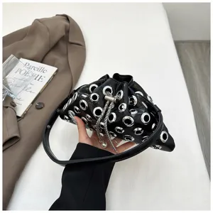 Black metallic grommet handbag slouchy shoulder bag with chain strap and pearl detail.