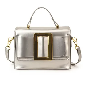 Silver metallic handbag with a bold gold buckle and top handle, chic retro crossbody bag for women