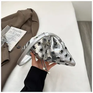 Silver metallic bucket bag with grommets and pearl chain strap, unique hollow design.