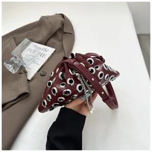 Metallic grommet bucket bag with pearl chain detail, chic crossbody shoulder bag for women.