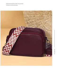 Detail view of the dark red PU leather crossbody bag with geometric woven strap and hardware.