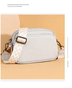 Detail view of the stylish leather crossbody bag featuring a wide geometric pattern strap.