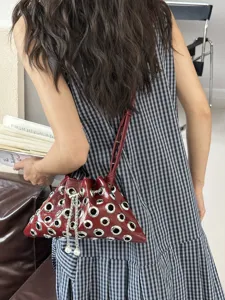 Wine red metallic grommet bucket bag with pearl chain, stylish shoulder bag for women main view.