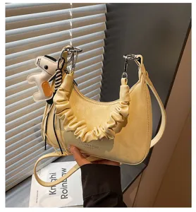 Yellow leather shoulder bag detail, stylish hobo handbag with cute dog pendant and pleat handle.