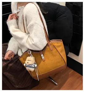 Élégant sac cabas en suédine marron avec porte-clés chiot, détail de sac à main chic.