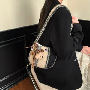 Detailed shot of winter lamb wool plaid crossbody bag with cute plush bear pendant and strap.