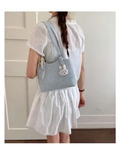 Light blue shoulder bag with cute rabbit charm, stylish daily tote for women commuting.