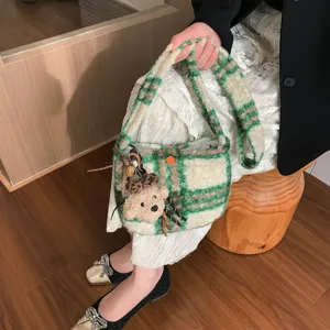 Green plaid lamb wool crossbody bag detail, featuring a cute plush bear charm and tweed fabric.