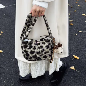 Close-up of fluffy leopard print handbag detail showing soft plush texture and cute bear charm.