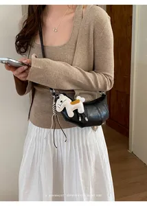 Detailed view of black leather croissant crossbody bag with cute charm and casual style.