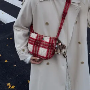 Close-up detail of the vintage red and white plaid sherpa crossbody bag with cute bear charm.