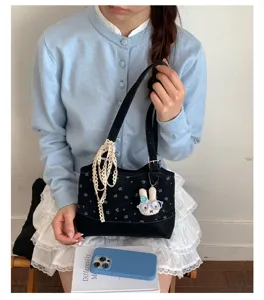 Detailed shot of Korean style fashion polka dot shoulder bag with cute rabbit pendant for daily commute.