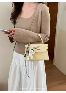 Yellow croc-embossed Kelly bag with metal lock and cute charm for women daily fashion.