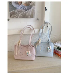 Korean style floral tote bag detail showing cute plush rabbit charm and lace tie decoration.
