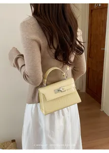Detail view of a stylish yellow stone pattern Kelly shoulder bag with chic metallic lock.