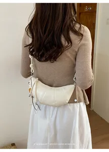 Minimalist white croissant crossbody bag detail, chic dumpling style for daily commuting.