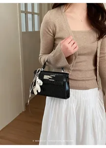 Black crocodile pattern women top handle Kelly bag detail with horse charm and chic ribbon.