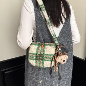 Detailed view of winter lamb wool plaid crossbody bag with cute plush bear pendant accessory.