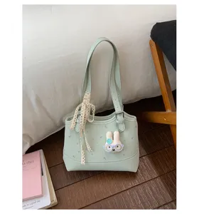 Detailed view of the mint green shoulder bag with cute rabbit pendant and lace ribbon.