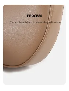Close-up detail of the stylish brown leather crescent underarm bag with curved design.
