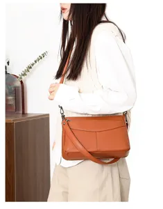 Close-up detail of the brown leather shoulder bag worn by model, showcasing fine texture.