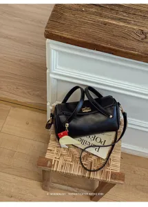 Borsa a mano nera minimalista con ciondolo, design rétro chic per uso quotidiano.