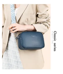 Blue genuine leather crossbody bag for women with wide patterned strap and zipper closure.