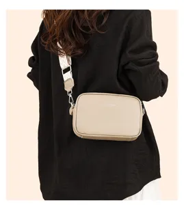 Detailed view of the stylish leather crossbody bag with a wide woven strap and compact design.