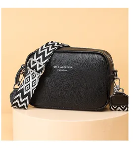 Black leather crossbody bag for women with wide patterned strap, stylish vintage camera bag.