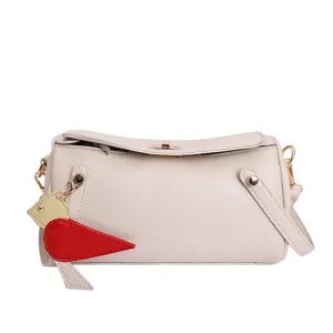 Borsa a tracolla cilindrica beige minimal con ciondolo a carota, borsa estiva chic ed elegante.