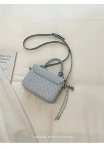 Bolso de mano pequeño tejido en azul claro con correa, vista de detalle estilo retro chic.