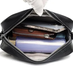 Black genuine leather crossbody bag main view showing multi-layer interior capacity design.