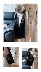 Detail shot of black leather shoulder bag with metal eyelets worn by model in coat.