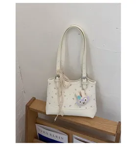 White floral PU leather shoulder bag detail showcasing delicate lace ribbon and cute rabbit charm.