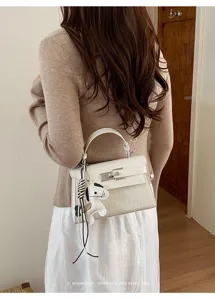 White crocodile pattern leather Kelly handbag with cute horse charm and top handle for women