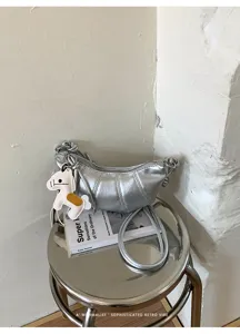 Silver metallic croissant shoulder bag, minimalist casual crossbody dumpling bag for daily commute.