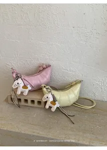 Detail view of minimalist croissant shoulder bag with cute horse charm and zip closure.