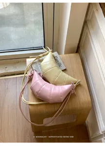 Detailed view of trendy pastel croissant crossbody bags in pink and yellow with cute knots.