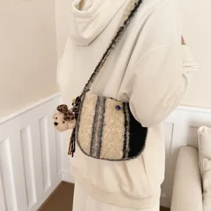Detail shot of women retro lamb wool plaid crossbody bag with cute bear pendant and strap.