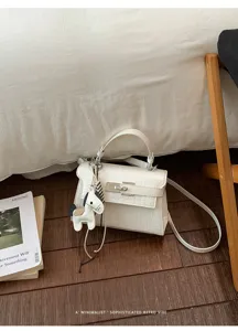 White crocodile pattern luxury shoulder handbag with classy Kelly style and cute horse charm.