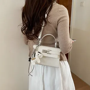 Elegant white crocodile pattern Kelly shoulder bag with chic top handle and charm.