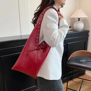 Vintage oil wax leather shoulder underarm bag with chic metal rivet and tie details for women.